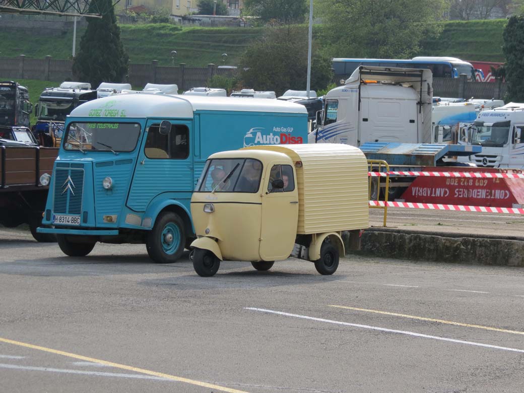 Aquí vemos un motocarro junto a una furgoneta Citroën HY, ambos protagonistas del transporte urbano iniciando la segunda mitad del siglo XX en España.